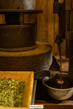 Alte Ölmühle bei der Pressung mit Kürbiskernen